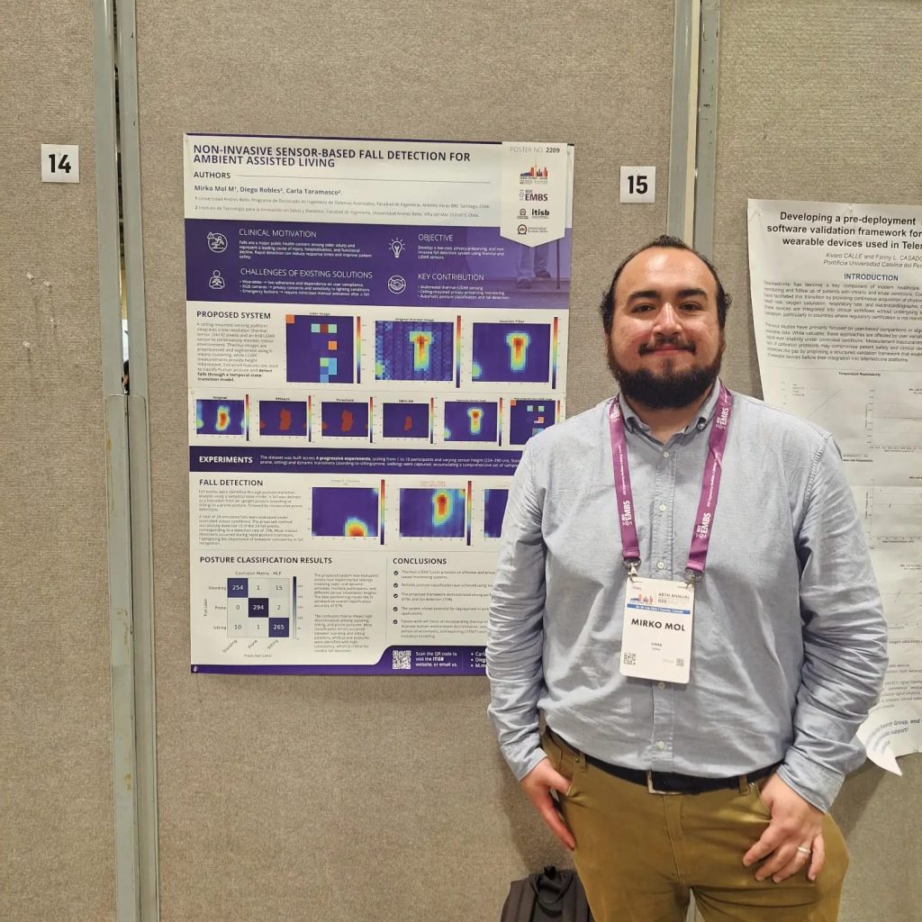 Bearded man in a light blue shirt and purple lanyard stands beside a conference poster on fall detection for ambient assisted living.